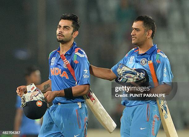 Indian cricket captain Mahendra Singh Dhoni greets batsman Virat Kohli after India won the ICC World Twenty20 cricket tournament second semi-final...