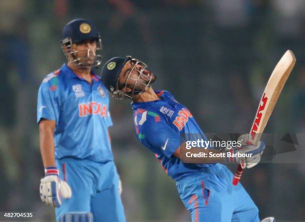 Virat Kohli of India screams after he hit the winning runs as MS Dhoni looks on as India win the ICC World Twenty20 Bangladesh 2014 2nd Semi-Final...