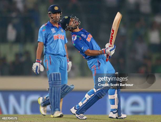 Virat Kohli of India screams after he hit the winning runs as MS Dhoni looks on as India win the ICC World Twenty20 Bangladesh 2014 2nd Semi-Final...