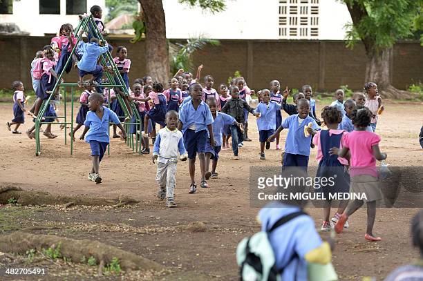 Bangui ce matin, Jo Christian est heureux de pouvoir accompagner son fils à l'école" - Children play in a school downtown Bangui on April 3, 2014....