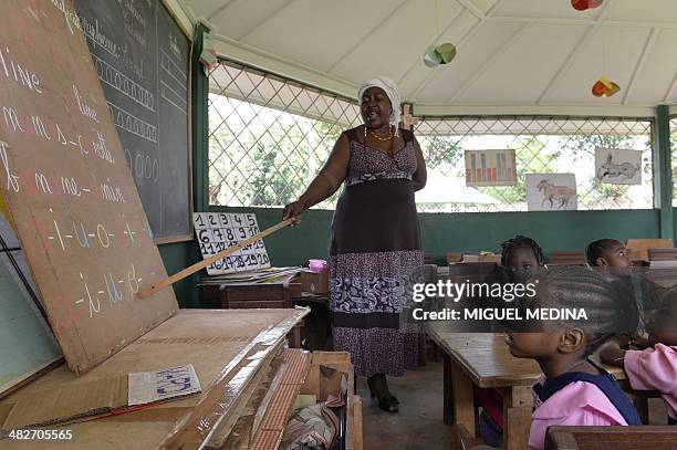 Bangui ce matin, Jo Christian est heureux de pouvoir accompagner son fils à l'école" - Children attend a lesson in a school downtown Bangui on April...