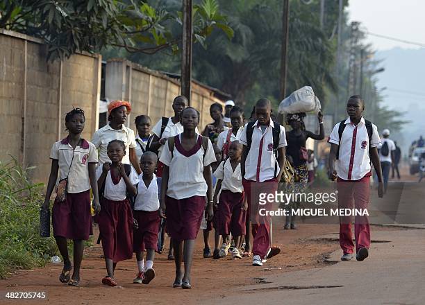 Bangui ce matin, Jo Christian est heureux de pouvoir accompagner son fils à l'école" - Children walk to a school downtown Bangui on April 3, 2014....