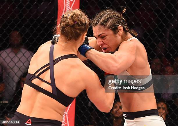 Ronda Rousey of the United States punches Bethe Correia of Brazil in their UFC women's bantamweight championship bout during the UFC 190 event inside...