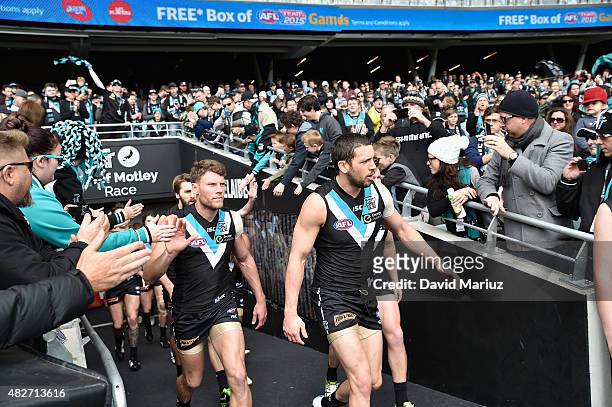 Port Adelaide players run onto the ground during the round 18 AFL match between the Port Adelaide Power and the St Kilda Saints at Adelaide Oval on...