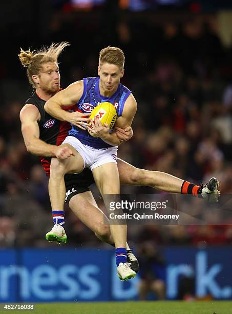 Lachie Hunter of the Bulldogs marks infront of Ariel Steinberg of the Bombers during the round 18 AFL match between the Essendon Bombers and the...