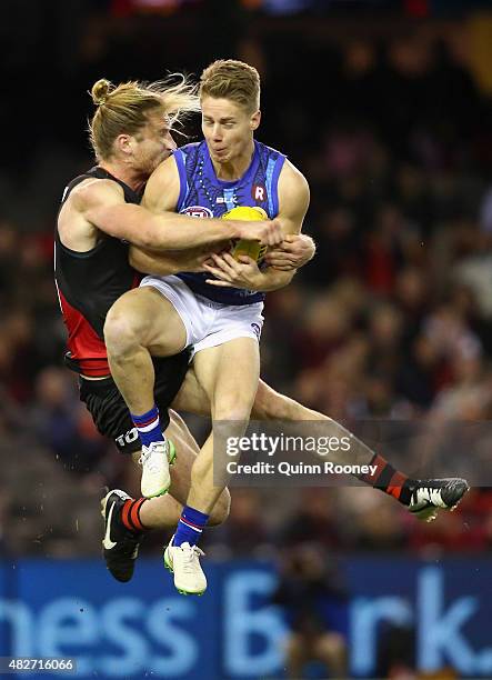 Lachie Hunter of the Bulldogs marks infront of Ariel Steinberg of the Bombers during the round 18 AFL match between the Essendon Bombers and the...