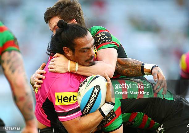 Sika Manu of the Panthers is tackled uring the round 21 NRL match between the South Sydney Rabbitohs and the Penrith Panthers at ANZ Stadium on...