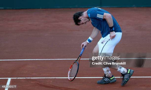 Andy Murray of Great Britain grabs his back after pulling up against Andreas Seppi of Italy during day one of the Davis Cup World Group Quarter Final...