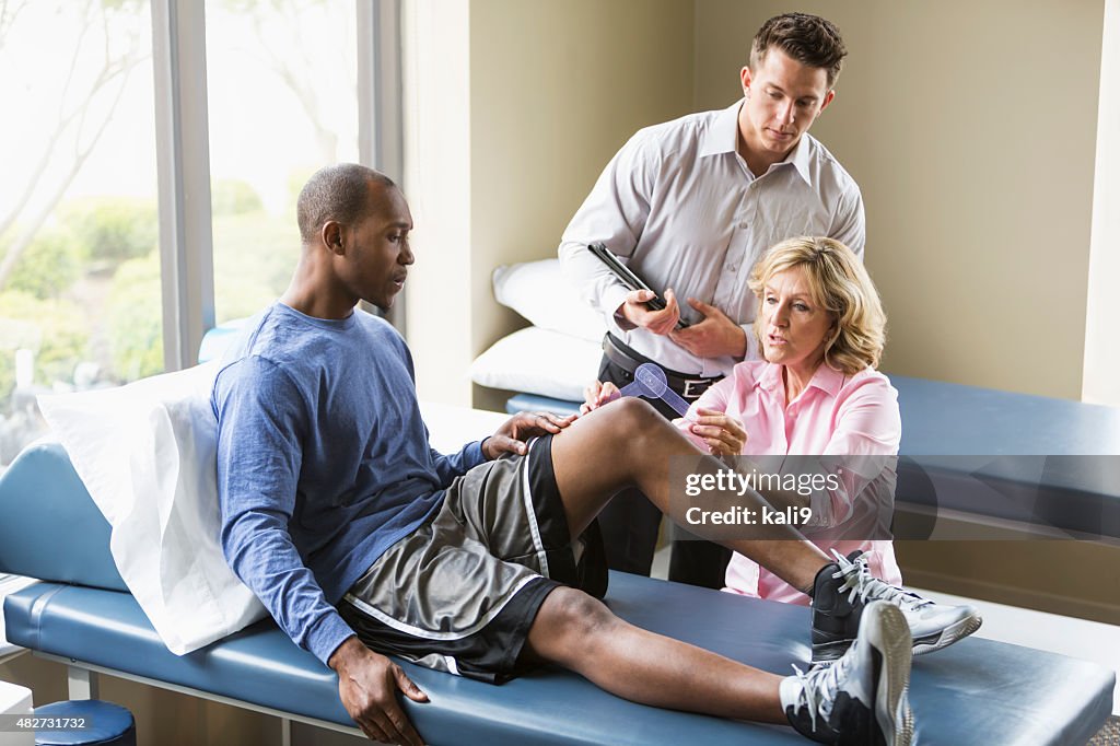 Physical therapists examining patient