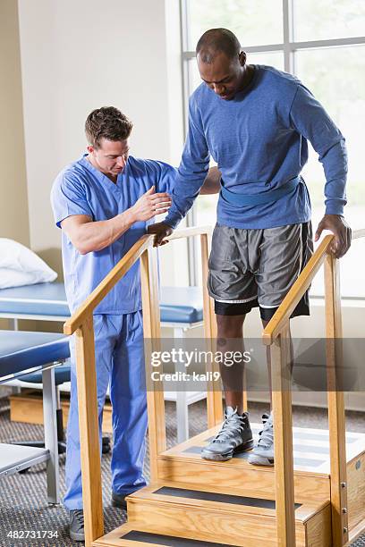 physical therapist helping patient on stairs - spinal column stock pictures, royalty-free photos & images