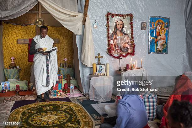 Kibrom Kasta leads an Orthodox service for Ethiopian and Eritrean worshippers at a church in a make shift camp near the port of Calais on August 2,...