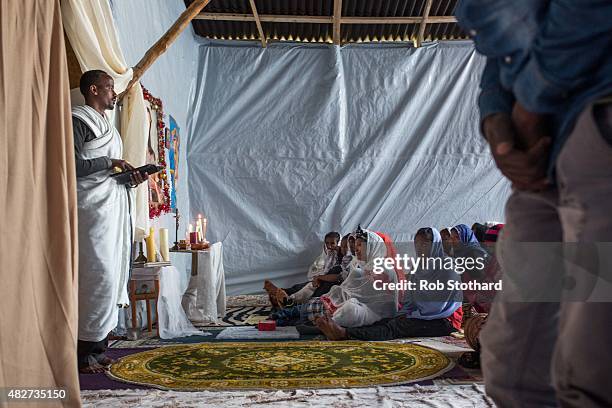 Kibrom Kasta leads an Orthodox service for Ethiopian and Eritrean worshippers at a church in a make shift camp near the port of Calais on August 2,...