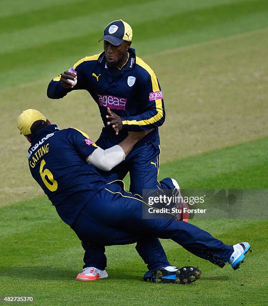 Hampshire fielder Michael Carberry takes a catch to dismiss Glamorgan batsman Aneurin Donald despite the attentions of his team mate Joe Gatting...