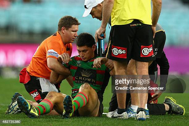 Kyle Turner of the Rabbitohs is assisted from the field after a concussion during the round 21 NRL match between the South Sydney Rabbitohs and the...