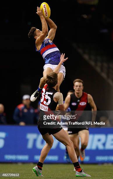 Luke Dahlhaus of the Bulldogs marks the ball over Martin Gleeson of the Bombers during the 2015 AFL round 18 match between the Essendon Bombers and...