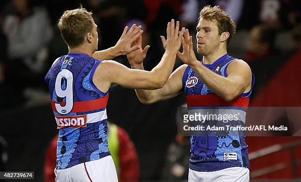 Jake Stringer and Stewart Crameri of the Bulldogs celebrate a goal during the 2015 AFL round 18 match between the Essendon Bombers and the Western...