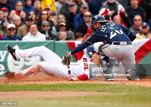 Grady Sizemore of the Boston Red Sox is tagged out at home plate by Jonathan Lucroy of the Milwaukee Brewers in the second inning during the Opening...