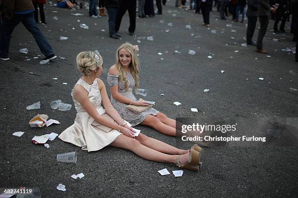 Racegoers relax as they enjoy the atmosphere of Ladies Day at the Aintree Grand National Festival meeting on April 4, 2014 in Aintree, England....