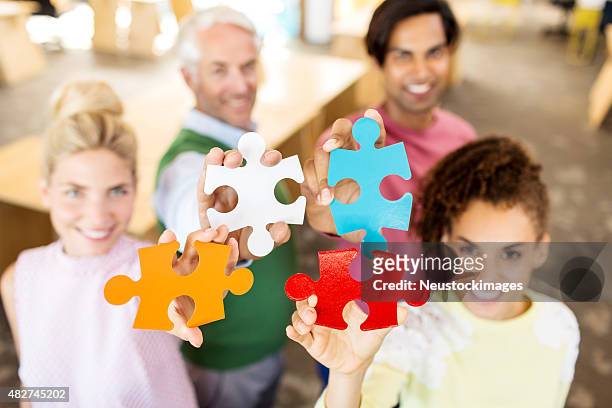 porträt von business team halten puzzle-stücke - puzzle 4 puzzle pieces stock-fotos und bilder