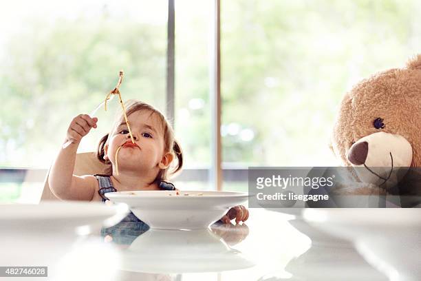 bambina 2 anni vecchia ragazza mangia spaghetti - baby eating toy foto e immagini stock