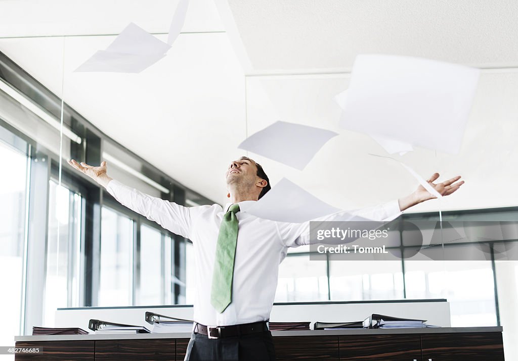 Businessman Throwing Paper In Office