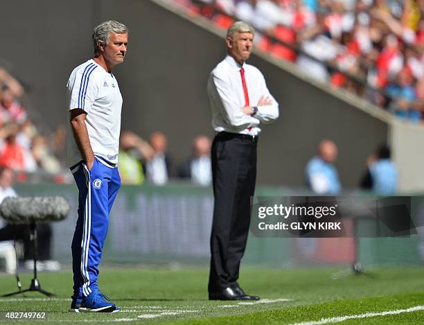 Chelsea's Portuguese manager Jose Mourinho and Arsenal's French manager Arsene Wenger watch from the side during the FA Community Shield football...