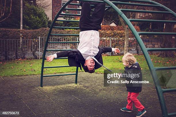 father and son playing in the park together - business suit tie stock-fotos und bilder