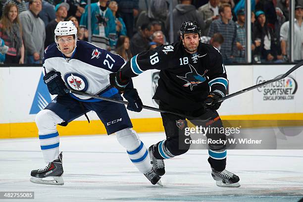 Eric Tangradi of the Winnipeg Jets skates against Mike Brown of the San Jose Sharks at SAP Center on March 27, 2014 in San Jose, California.