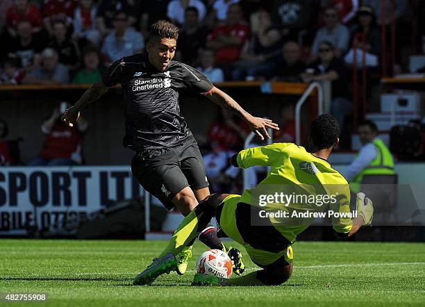 Roberto Firmino of Liverpool goes in on Lawrence Vigouroux of Swindon Town during a preseason friendly at County Ground on August 2, 2015 in Swindon,...