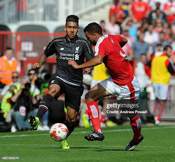 Roberto Firmino of Liverpool in action with Kevin Stewart of Swindon Town during a preseason friendly at County Ground on August 2, 2015 in Swindon,...