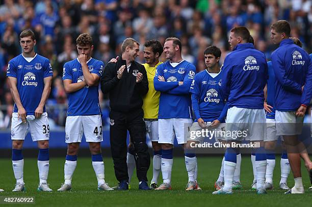 Wayne Rooney of Everton and Manchester United shares a joke Tony Hibbert of Everton at the end of the Duncan Ferguson Testimonial match between...