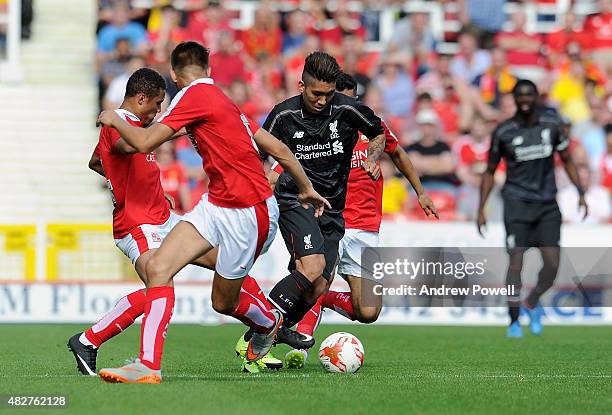 Roberto Firmino of Liverpool competes with James Dayton of Swindon Town during a pre-season friendly at County Ground on August 2, 2015 in Swindon,...