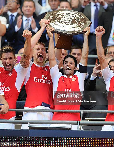 Arsenal captain Mike Arteta and vice captain Per Mertesacker lift the Community shield after the FA Community Shield match between Chelsea and...