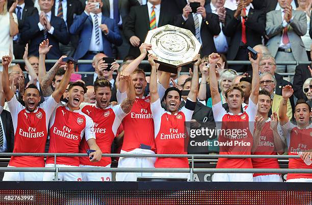 Francis Coquelin, Hector Bellerin, Olivier Giroud, Per Mertesacker, Mikel Arteta and Nacho Monreal of Arsenal lift the Community Shield after the FA...