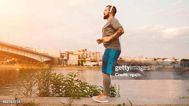 halten sie sich fit in der stadt. - fat guy running stock-fotos und bilder