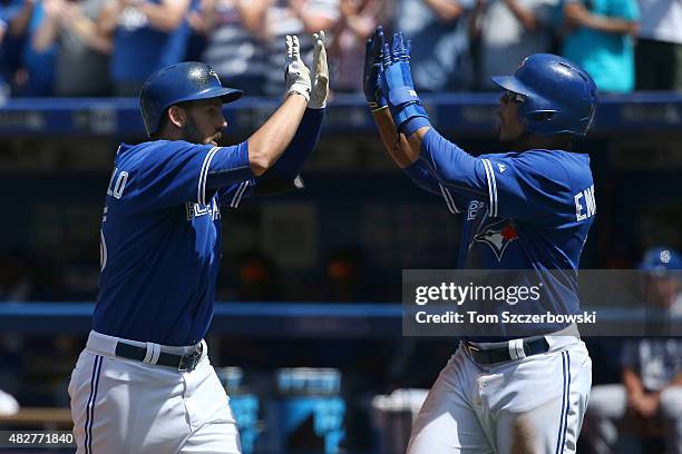 Chris Colabello of the Toronto Blue Jays is congratulated by Edwin Encarnacion after hitting a two-run home run in the fourth inning during MLB game...