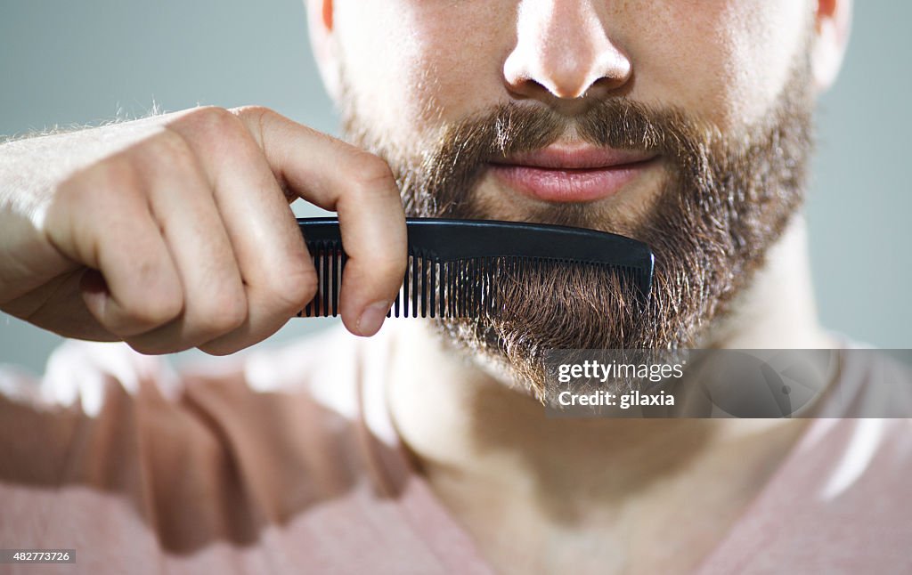 Hombre irreconocible peinar su barba