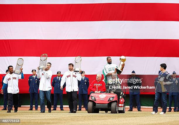 Former Boston mayor Thomas Menino is given a ride by former Boston Bruins player, Mark Recchi, accompanied by former members of the Boston Red Sox,...