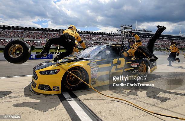 Brad Keselowski, driver of the Alliance Truck Parts Ford, crashes into his crew on pit road during the NASCAR Sprint Cup Series Windows 10 400 at...
