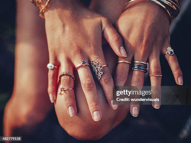 estilo boho girl's hands looking femenina con muchos anillos - anillo joya fotografías e imágenes de stock
