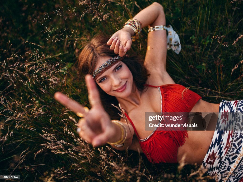 Hippie girl lying in wild grass mit einem peace-Zeichen