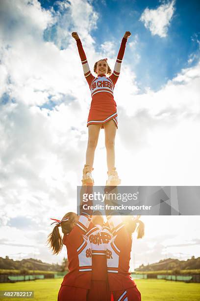 cheerleader girl on top of the success - college sports team stock pictures, royalty-free photos & images
