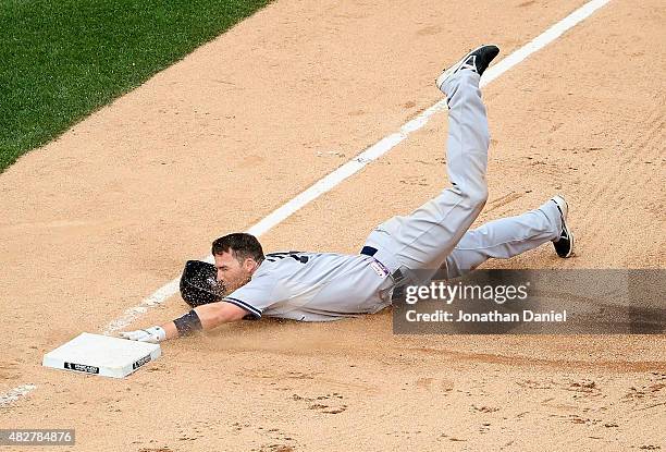 Stephen Drew of the New York Yankees dives into third base after hitting a two-run triple in the 7th inning against the Chicago White Sox at U.S....