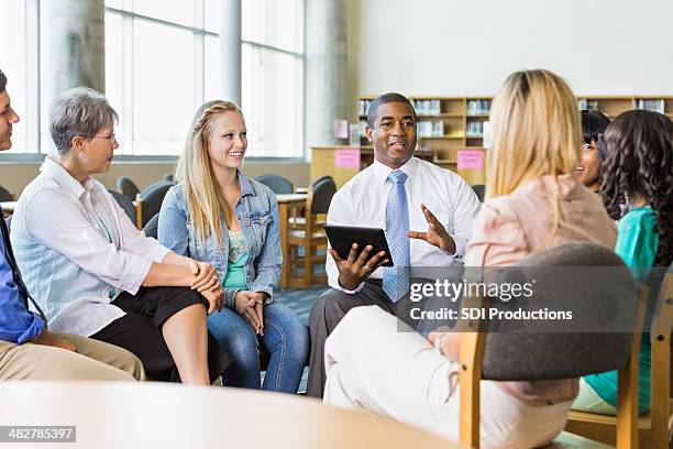 man leading discussion group of adults and teens - elderly cognitive stimulation therapy stockfoto's en -beelden