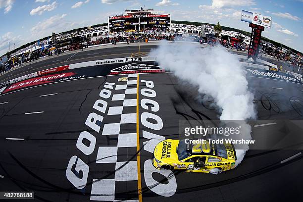 Matt Kenseth, driver of the Dollar General Toyota, celebrates with a burnout after winning the NASCAR Sprint Cup Series Windows 10 400 at Pocono...