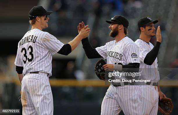 Charlie Blackmon of the Colorado Rockies celebrates with teammates Justin Morneau and Nolan Arenado after they defeated the Arizona Diamondbacks...