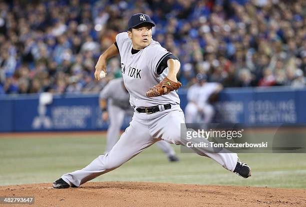 Masahiro Tanaka of the New York Yankees delivers the first pitch of his MLB career in the first inning during MLB game action against the Toronto...