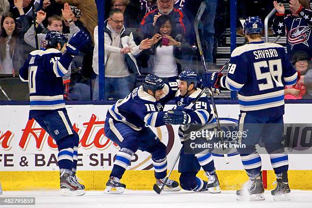 Derek Mackenzie of the Columbus Blue Jackets is congratulated by R.J. Umberger, Jared Boll and David Savard after scoring a goal against the Chicago...