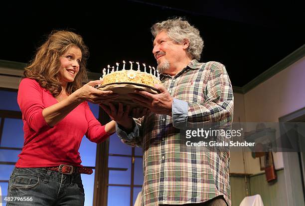 Volker Brandt and his partner Susanne Meikl with a birthday cake during the 80th birthday celebrations for Volker Brandt at Komoedie on August 02,...