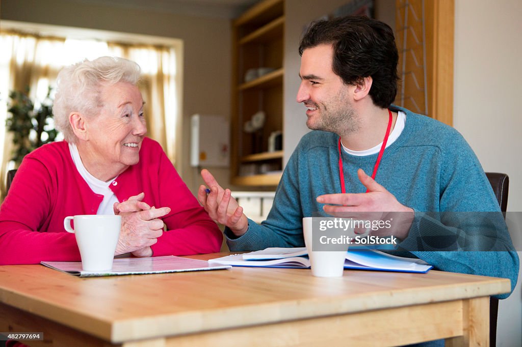 Friendly male volunteer assisting a senior woman with paperwork.